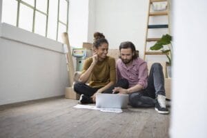 Tampa Home Inspectors man and woman sitting on a floor searching something with their laptop