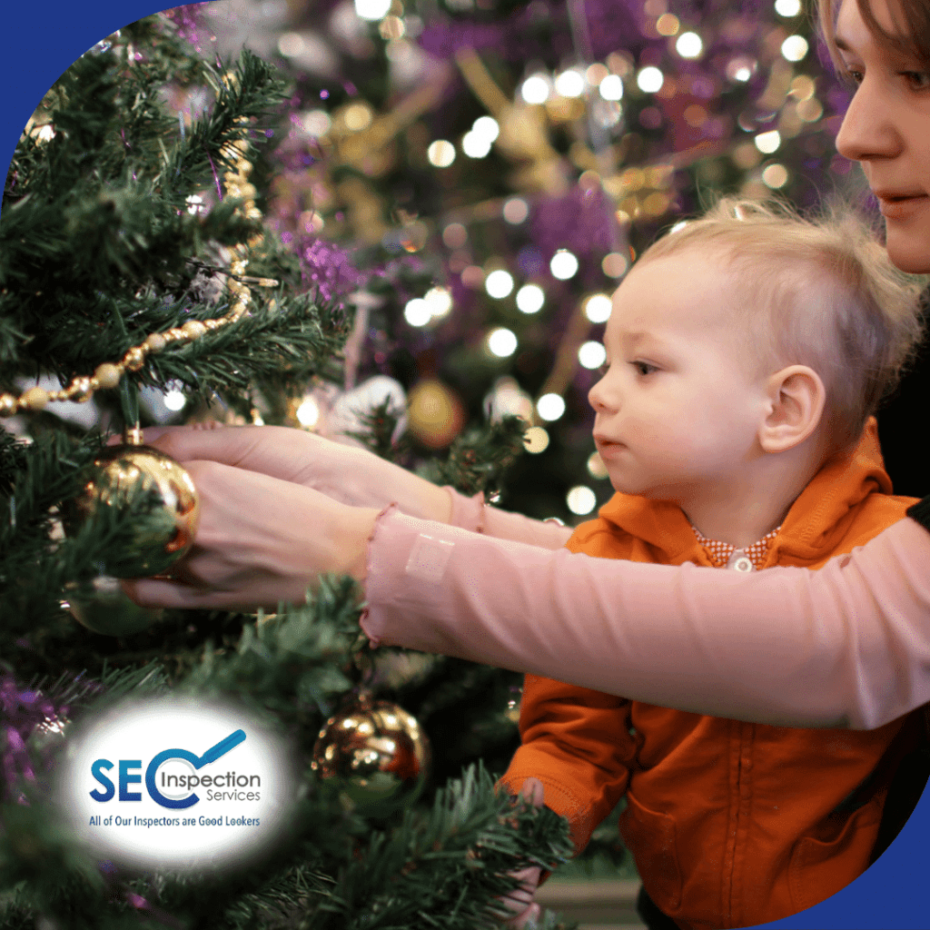 Mother and child decorating a Christmas tree with golden ornaments.