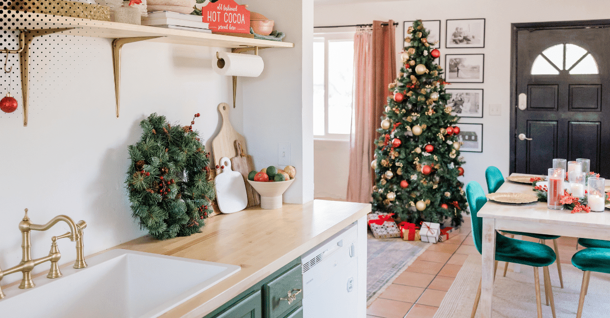 Holiday kitchen with wreath and Christmas tree in dining area.