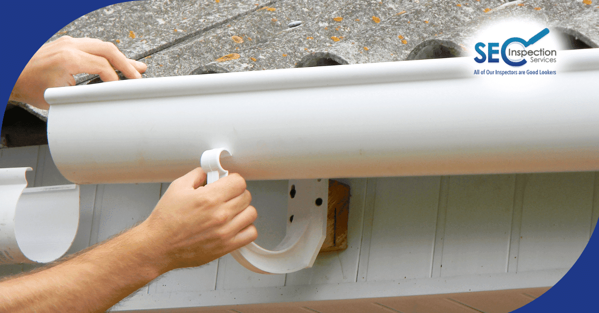 Hands installing or repairing residential gutter system.